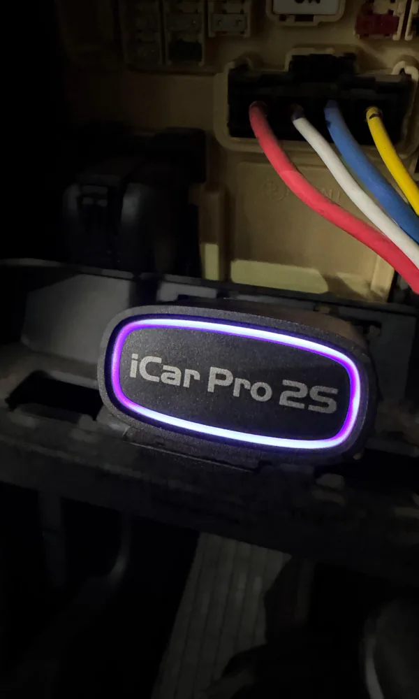 Escáner iCar Pro 2S conectado al puerto OBD2, con su luz encendida
